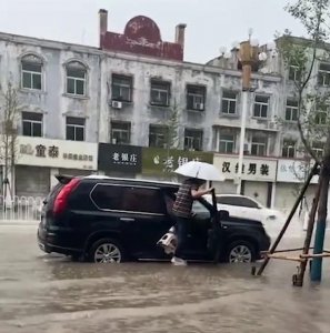 ​大雨路面积水严重，男子为不湿鞋上车用凳子自创“踩水神器”